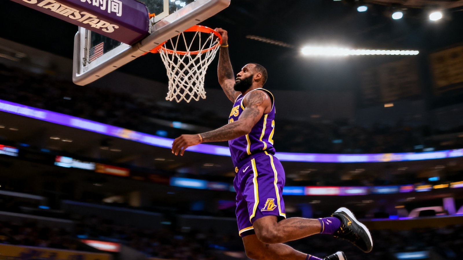 NBA常规赛洛杉矶湖人队主场，一名身穿紫金球衣的球员飞身单手扣篮，篮筐上方计时器显示第四节剩余时间